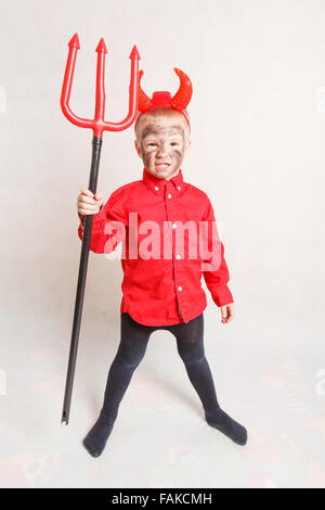 Little Boy con trident in un diavolo costume (su sfondo bianco). Foto Stock