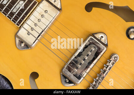 Si tratta di una parte del corpo di un giallo di chitarra elettrica che di legno e metallo. Ci sono 6-imbracare il componente di fissaggio con il b Foto Stock