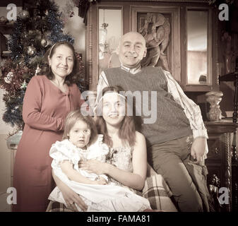 Imitazione di vecchie foto di famiglia felice di tre generazioni al tempo di Natale Foto Stock