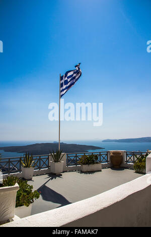 Sventola bandiera greca sulla piattaforma di osservazione a Santorini, verticale Foto Stock