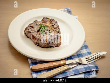 Succose grigliate costata di manzo con posate, dai toni rétro Foto Stock