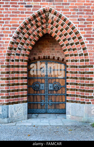 Primo piano su una porta della chiesa in un arco gotico Foto Stock