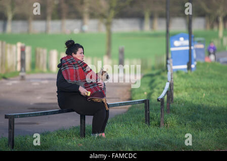 Lone donna e il suo cane - la donna e il suo cane seduto su una recinzione a East Beach in Shoeburyness in Essex, UK. Foto Stock