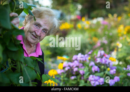 Una vecchia donna nel suo giardino. Foto Stock
