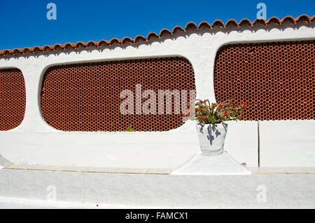 Spagnolo bianco e marrone di architettura con fiore decorativo sulla pentola la recinzione Foto Stock