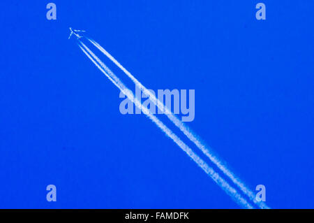 Un passeggero jet lasciando una scia di vapore in un cielo blu Foto Stock