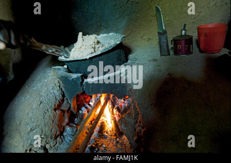 Pasto di cottura su un fuoco aperto in una piccola cucina di base unità, Kenya. Foto Stock