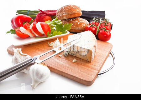 Deliziosi pomodori a grappolo, pane e formaggio sulla tavola di legno Foto Stock