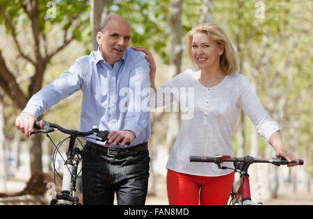 Sorridente coppia internazionale di pensionati attivi con le bici per esterno Foto Stock