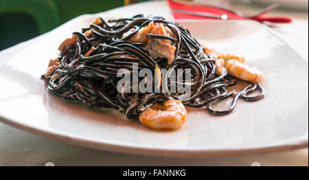 Inchiostro nero spaghetti con salsa di panna e gamberi Foto Stock