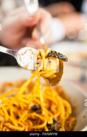 La cena per gli ospiti fino a rotolamento spaghetti su una forcella. Primo piano Foto Stock