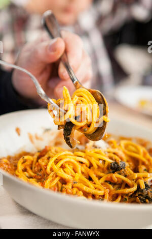 La cena per gli ospiti fino a rotolamento spaghetti su una forcella. Primo piano Foto Stock