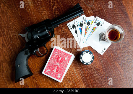 Il vecchio west gioco di poker con sei sparatutto, whiskey, carte chip e. Un royal flush mostra Foto Stock