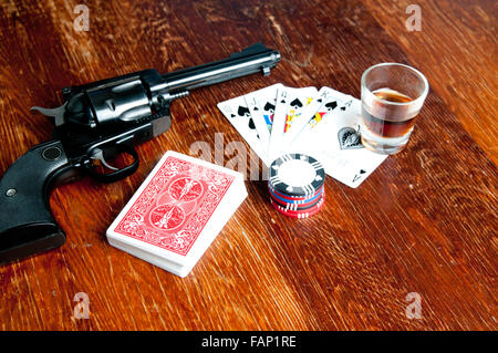 Il vecchio west gioco di poker con sei sparatutto, whiskey, carte chip e. Un royal flush mostra Foto Stock