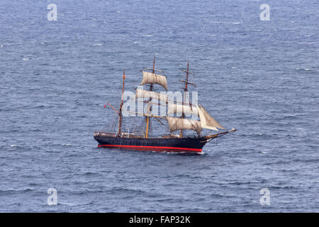 Tall Ship con vele in mare aperto in una giornata di sole antenna vista laterale durante la gara con i turisti a bordo del pianale superiore Foto Stock