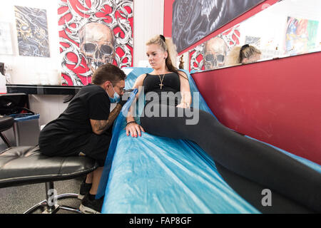 Aesch, Svizzera. 14 Ago, 2015. Dennis Weber (L), un uomo con nanismo, tatuaggi Ramona Hopfner in un tattoo studio in Aesch, Svizzera, 14 agosto 2015. Molte persone con nanismo affrontare problemi durante la ricerca di un lavoro. Foto: PATRICK SEEGER/dpa/Alamy Live News Foto Stock