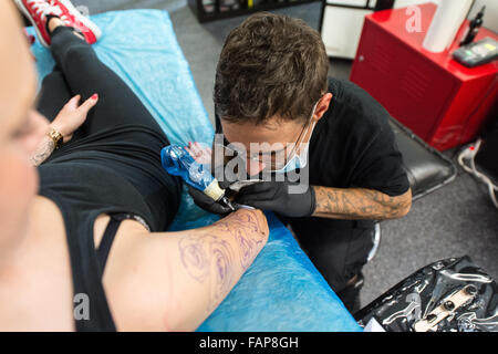 Aesch, Svizzera. 14 Ago, 2015. Dennis Weber (R), un uomo con nanismo, tatuaggi Ramona Hopfner in un tattoo studio in Aesch, Svizzera, 14 agosto 2015. Molte persone con nanismo affrontare problemi durante la ricerca di un lavoro. Foto: PATRICK SEEGER/dpa/Alamy Live News Foto Stock