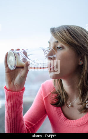 Donna di bere una pinta di Guinness Foto Stock