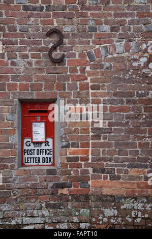 La scatola a muro di Ludlow. Un britannico tradizionale montato a parete red letterbox dal regno di George V. In Moreton village. Il Dorset, Inghilterra, Regno Unito. Foto Stock