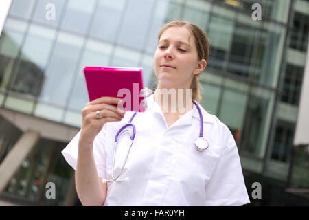 Giovane medico la lettura di un blocco note Foto Stock