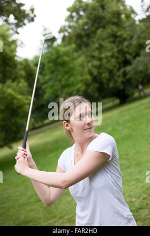 Giovane donna di rinvio off sul campo da golf Foto Stock