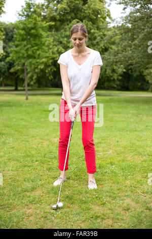 Giovane donna di rinvio off sul campo da golf Foto Stock