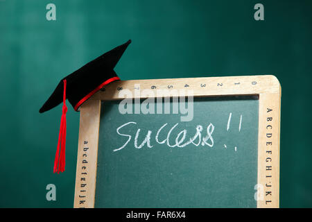 Graduazione hat sulla lavagna. Foto Stock