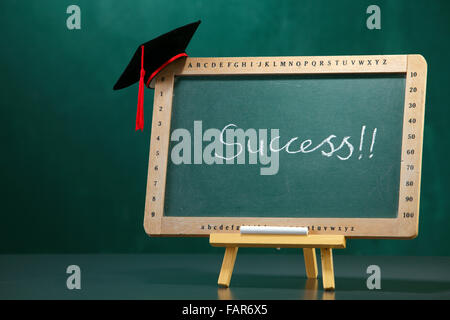 Graduazione hat sulla lavagna. Foto Stock