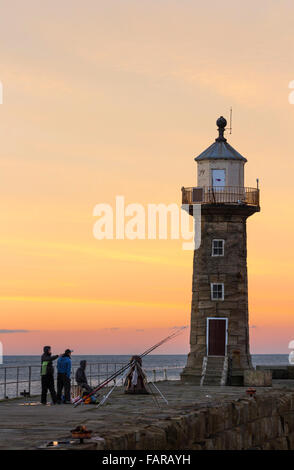 I pescatori sul molo di Whitby al tramonto. Whitby, North Yorkshire, Inghilterra. Regno Unito Foto Stock