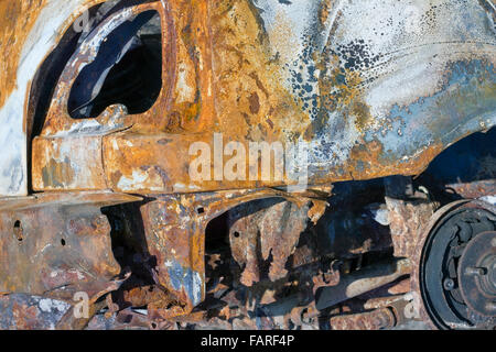 Il furto del girato bruciato auto in un fosso dopo incidente crash closeup sfondo Foto Stock