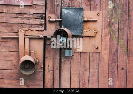 Il rosso tettoia in legno è bloccato su tre lucchetti closeup sfondo Foto Stock