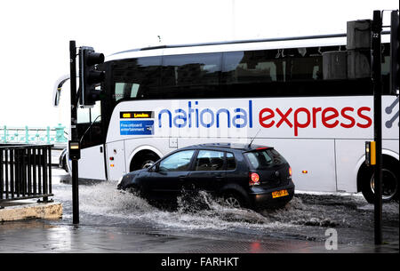 Brighton, Sussex, Regno Unito. 4 gennaio, 2016. Unità di traffico attraverso le inondazioni e le acque di superficie sul lungomare di Brighton vicino alla giunzione con West Street dopo più violenti acquazzoni di pioggia questa mattina Credito: Simon Dack/Alamy Live News Foto Stock