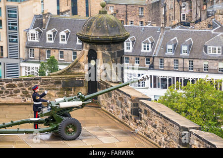 Il castello di Edimburgo un soldato si prepara a fuoco il uno o' bloccare la pistola dal mulino per montare la batteria. Il castello di Edimburgo in Scozia UK GB EU Europe Foto Stock