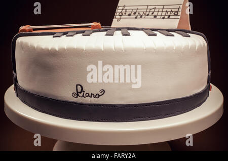 Torta di compleanno decorata con fondente, arrotondato, simbolicamente la presentazione di pianoforte e violoncello strumenti. Foto Stock