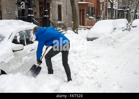 L'uomo spalare e rimozione di neve da auto a Montreal, Canada, 30 dicembre 2015. Foto Stock