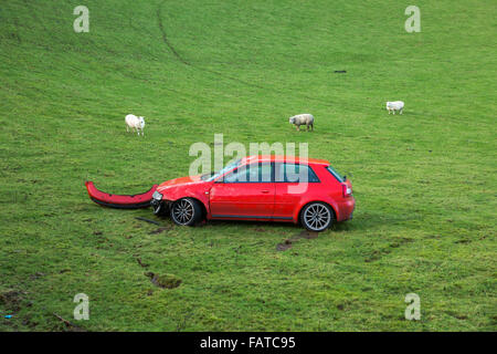 Danneggiato Audi rosso quello è andato fuori della strada in un campo Foto Stock