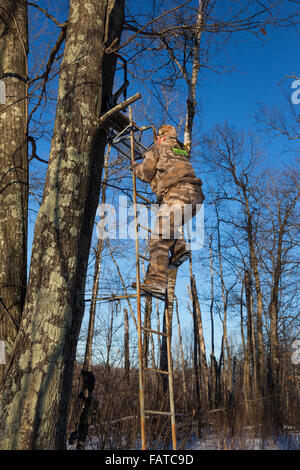 Crossbow hunter salendo una scaletta Foto Stock