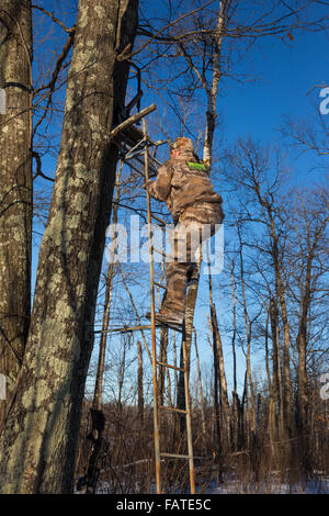 Crossbow hunter salendo una scaletta Foto Stock