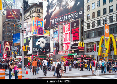 Turisti e visitatori di ammirare le attrazioni vicino alla statura di George M. Cohan in Duffy Square a Times Square di New York City. Foto Stock