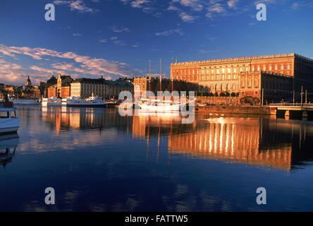 Barche ancorate lungo Skeppsbron all'alba con il Palazzo Reale e la Città Vecchia di Stoccolma Foto Stock