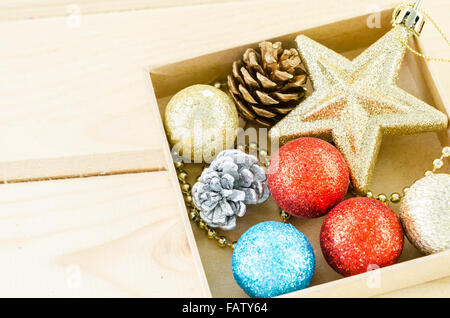 Le decorazioni di Natale nella casella su sfondo di legno. Foto Stock