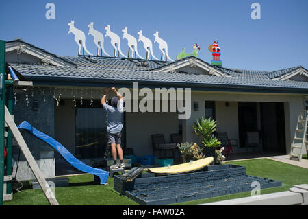 Adelaide Australia. 5° gennaio 2016. Un uomo smantella le decorazioni di Natale sulla sua casa sulla dodicesima notte in Adelaide decorato con sei white boomers (canguri) tirando una Santa sleigh Credito: amer ghazzal/Alamy Live News Foto Stock