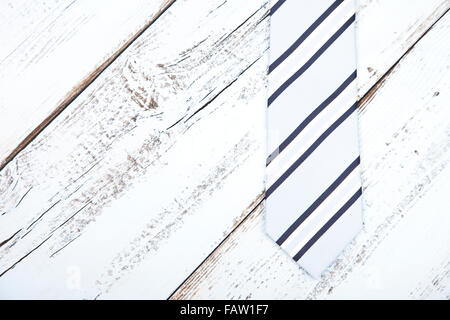 Tirante di business su luce blu sullo sfondo di legno Foto Stock