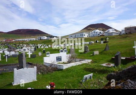 Città di Heimaey e cimitero, isole Westman, con Vulcano Eldfell (l) e Helgafell, Islanda Foto Stock