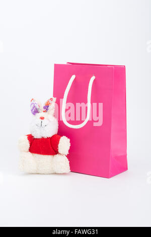 Rosa shopping bag e orso di peluche su sfondo bianco Foto Stock