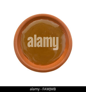 Vista dall'alto di una porzione di caramello topping di caramella in un piccolo recipiente isolato su uno sfondo bianco. Foto Stock