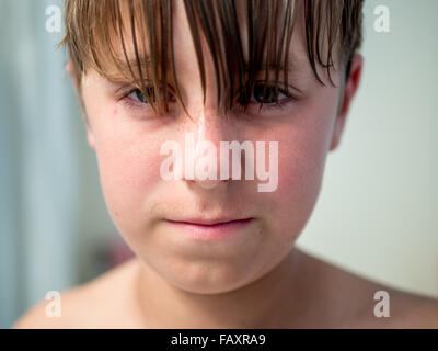 Close up ritratto di ragazzo adolescente dai lunghi capelli in necessità di taglio di capelli Foto Stock