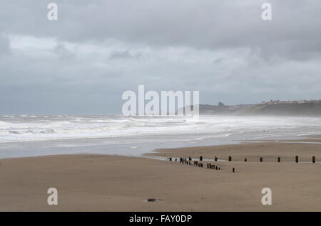 Sandsend spiaggia con una vista verso Whitby durante un ventoso giorno grigio in estate, nello Yorkshire, Inghilterra Foto Stock