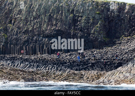 Il basalto colonne esagonali esposti sopra l'acqua di mare. I turisti a piedi sul sentiero a fianco di Fingal's Cave. Staffa. A ovest della Scozia Foto Stock