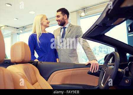 Coppia felice l'acquisto di auto in auto show o salon Foto Stock